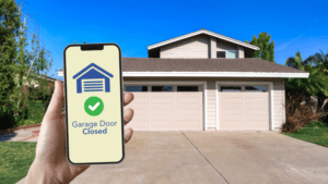 A phone reads “Garage Door Closed” on a smart technology app.