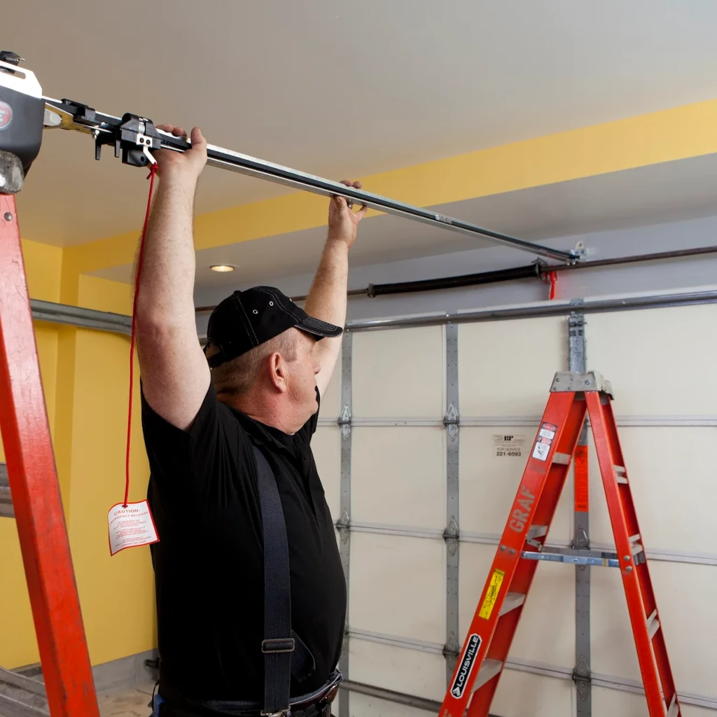 Person installing a garage door motor.