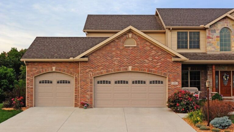 A brick house with two large garage doors that match the style.