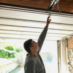 A man reaches up to grab the safety rope on his garage door.