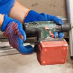 A garage technician tightens the bolts on a garage track.