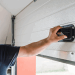 A man pulls up on the interior handle of a garage door.