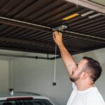 A man opens his garage door to inspect it for subtle damage.