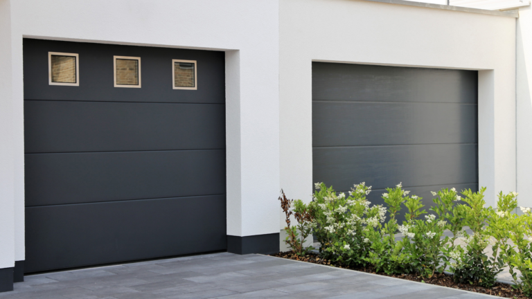 Two sleek, single garage doors, one with small square windows